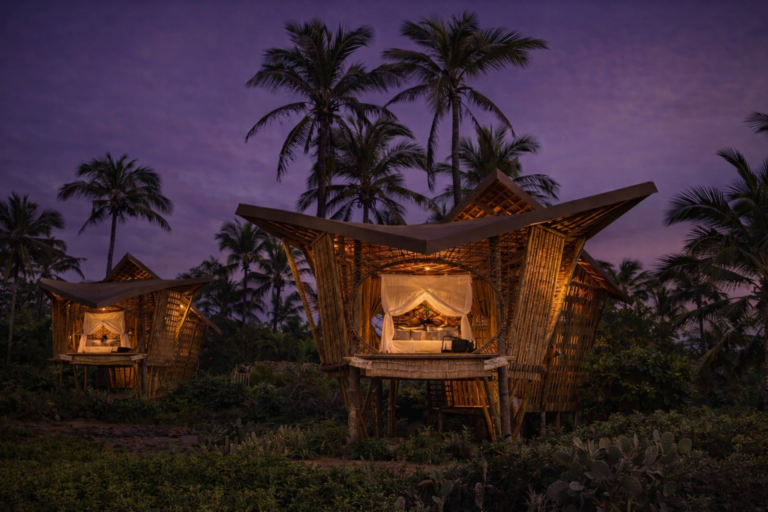 luxury eco bamboo villas illuminated at night in tropical resort landscape