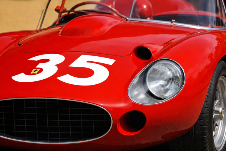 AI-generated image of a classic Ferrari Mille Miglia race car with number 35, showing a close-up of the red vintage racing body and headlight detail.