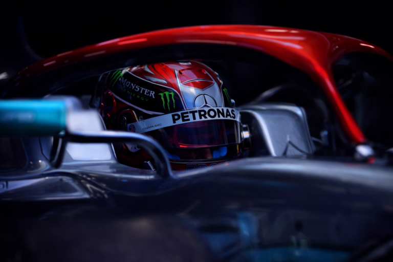 AI-generated close-up image of a Formula 1 driver sitting inside the cockpit of a modern F1 car, with the helmet visible beneath the halo safety device.