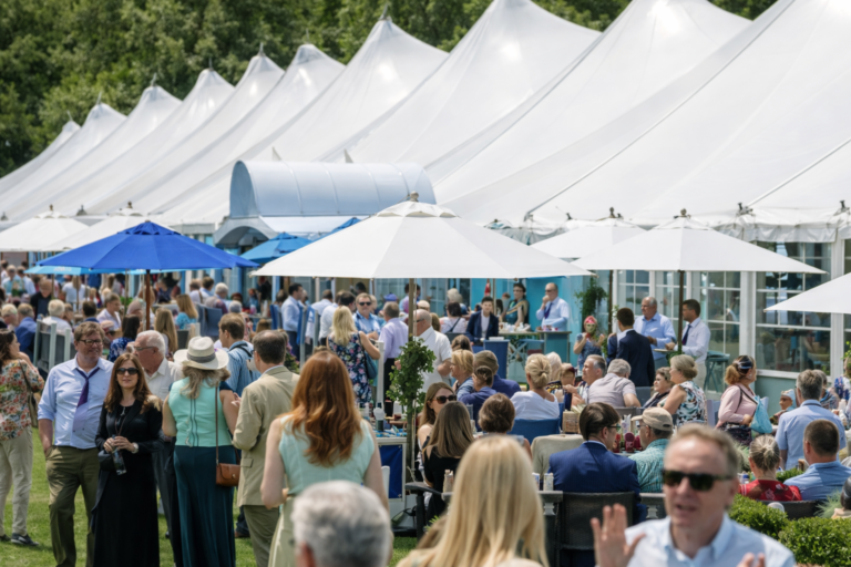 AI-generated image of guests socializing at a luxury outdoor food and wine festival with white event pavilions and elegant garden seating.